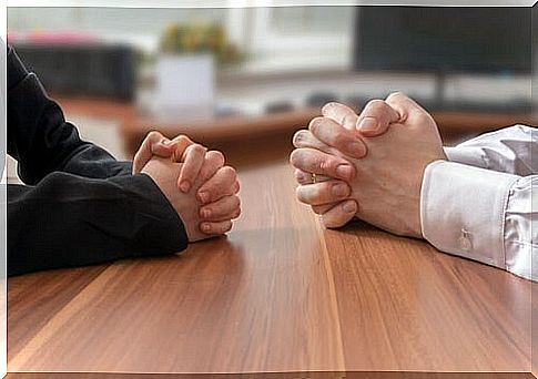 Hands of two people on a table while arguing