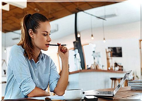 Woman thinking in a coffee shop about the cover letter to apply for a job