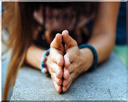 Woman with folded hands thinking of gratitude phrases