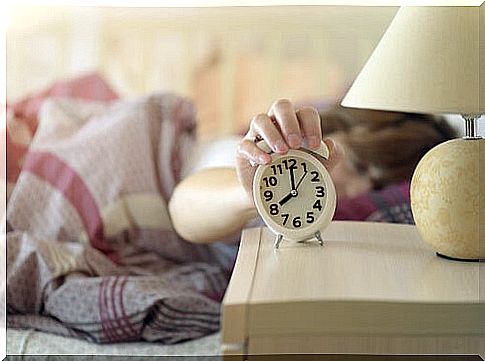 Woman turning off her alarm clock