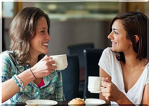 Girlfriends sharing while having coffee