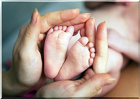 Mother's hands surrounding her son's feet