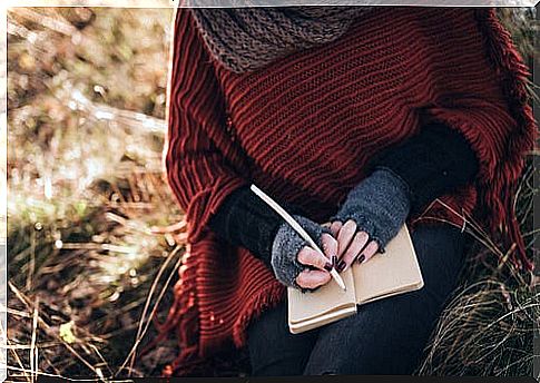 Woman writing with pen on a notebook