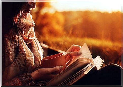 Woman reading a book with a coffee thinking about the savoring technique