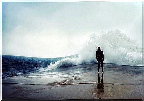 Man looking at a wave in the sea