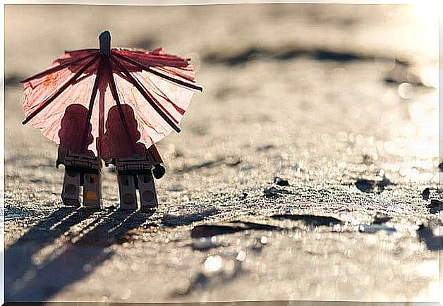 Two dolls under an umbrella