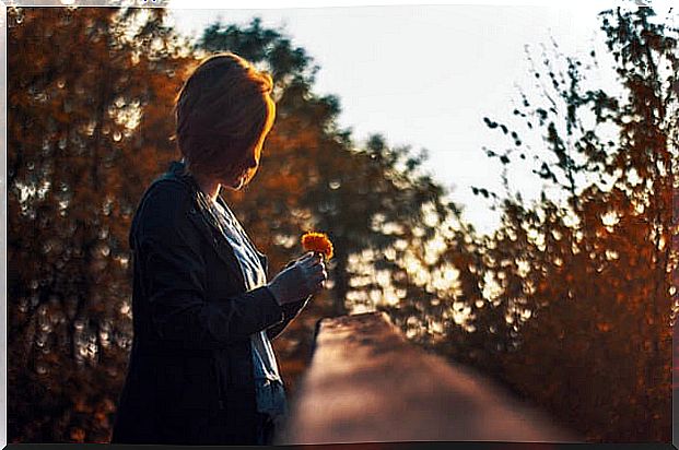 Woman thinking what she does not want to forget while looking at flower