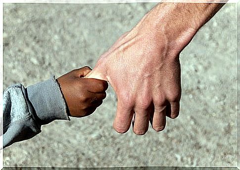 Hand of a Syrian child holding that of an adult