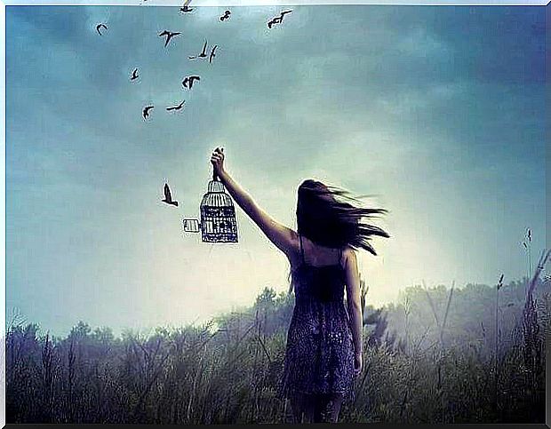 Woman letting birds free in their cage